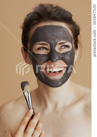 smiling woman with brush and facial mask 101647520