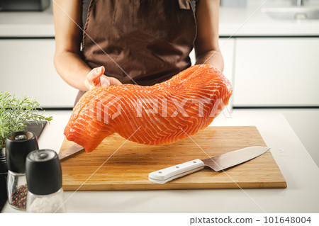 Women hold a raw salmon fillet Women hold a raw salmon fillet 101648004
