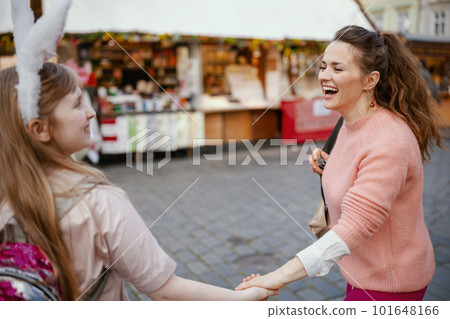 smiling modern mother and child walking at fair in city 101648166