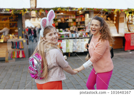 smiling mother and teenage daughter walking at fair in city 101648167