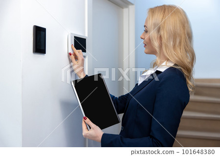 Concentrated young female adjusting the home automation 101648380