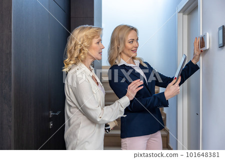 Friendly real estate agent showing a smart house to a potential buyer 101648381