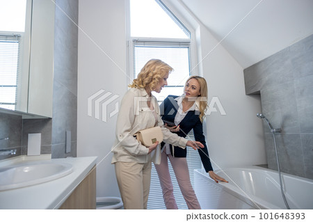 Young realtor demonstrating a house interior to a potential buyer Young realtor demonstrating a house interior to a potential buyer 101648393