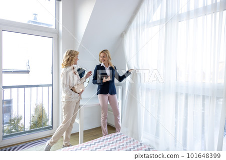 Real estate agent demonstrating a new house to a woman Real estate agent demonstrating a new house to a woman 101648399