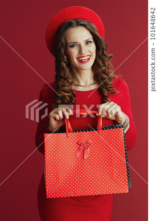 smiling stylish 40 years old woman in red dress and beret 101648642
