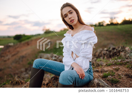 Young cheerful woman wearing cowgirl boots posing in the countryside. Fashion, style, lifestyle concept 101648753
