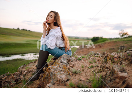Young cheerful woman wearing cowgirl boots posing in the countryside. Fashion, style, lifestyle concept 101648754