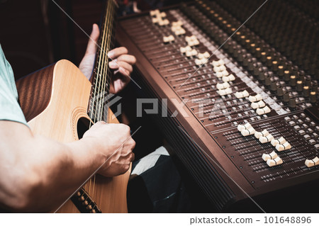 close up male musician, composer playing acoustic guitar in studio. acoustic musical instrument recording or songwriting concept 101648896