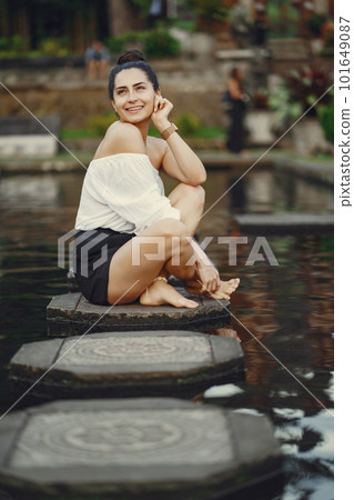 girl exploring a beautiful park in Bali. Brunette girl dressed in stylish clothing posing in a beautiful location girl exploring a beautiful park in Bali. Brunette girl dressed in stylish clothing posing in a beautiful location 101649087