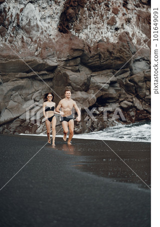 couple relaxing at a secluded private beach in Bali Indonesia. couple showing affection on a hidden beach. Couple wearing bathingsuits 101649091