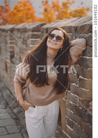 stylish girl wearing sunglasses visiting the Great Wall of China near Beijing during autumn season. Brunette girl at one of the 7 wonders of the world stylish girl wearing sunglasses visiting the Great Wall of China near Beijing during autumn season. Brunette girl at one of the 7 wonders of the world 101649182