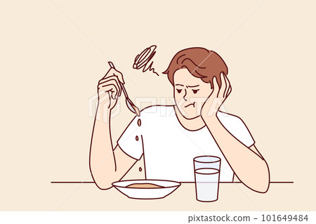 Man suffers from lack of appetite sitting at table in kitchen and does not want to eat breakfast Man suffers from lack of appetite sitting at table in kitchen and does not want to eat breakfast 101649484