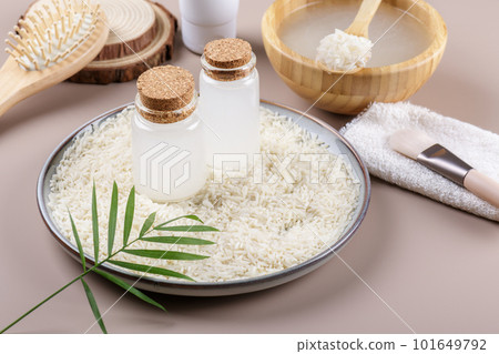Two bottle with rice water on plate with rice on beige backgrounda, natural skincare preparation 101649792