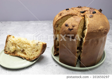 Closeup Panettone Italian Sweet Cake On Table And Cut Piece. Sweet bread, Fruitcake Originally From Italy, Milan Baked Dessert. Horizontal plane. Closeup Panettone Italian Sweet Cake On Table And Cut Piece. Sweet bread, Fruitcake Originally From Italy, Milan Baked Dessert. Horizontal plane. 101650297