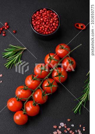 Delicious fresh cherry tomatoes on a twig on a dark concrete background 101650775