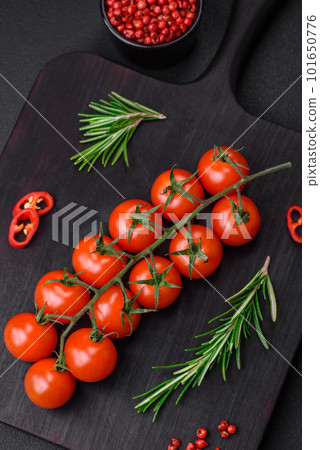 Delicious fresh cherry tomatoes on a twig on a dark concrete background Delicious fresh cherry tomatoes on a twig on a dark concrete background 101650776