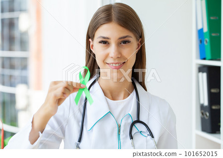 Green ribbon in hand as a symbol to awareness Lymphoma cancer 101652015