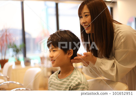 Female hairdresser cutting boy's hair 101652951