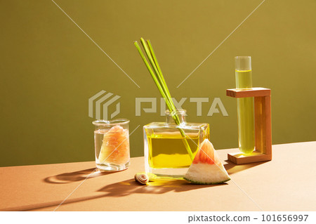 Transparent glass bottle full filled with essential oil extracted from pink pomelo (Citrus maxima) and lemongrass. Empty label for cosmetic product mockup Transparent glass bottle full filled with essential oil extracted from pink pomelo (Citrus maxima) and lemongrass. Empty label for cosmetic product mockup 101656997