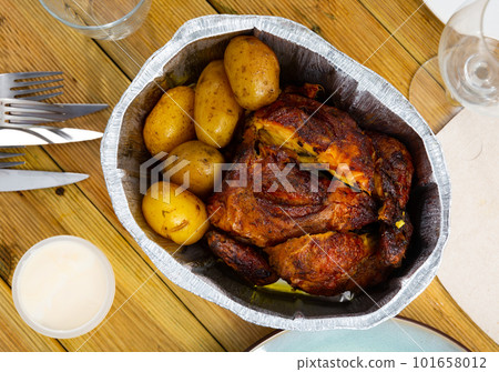 Serving of delicious baked chicken and potatoes placed on table Serving of delicious baked chicken and potatoes placed on table 101658012