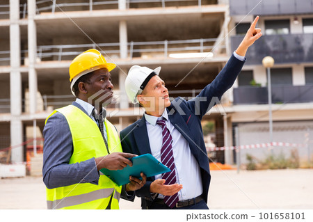 Young architect discusses a construction plan with an engineer Young architect discusses a construction plan with an engineer 101658101