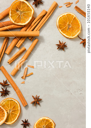 Dried orange slices, star anise and cinnamon sticks are decorated on minimalist background with blank space to promote cosmetic product extracted from these herbals. Benefiting health, skin and hair 101658140
