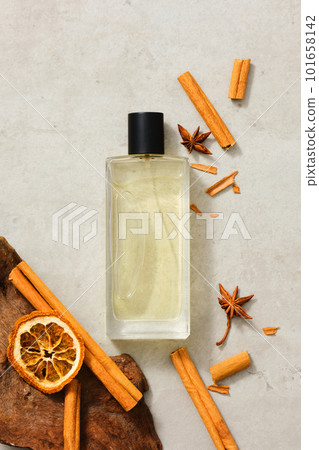 A transparent bottle containing essential oil extracted from cinnamon (Cinnamomum), star anise and dried orange slice. Healthy herbals concept. Top view, overhead 101658142