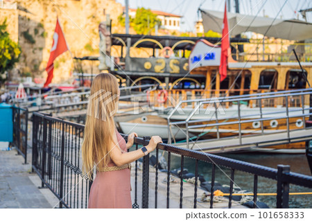 Woman tourist in Old town Kaleici in Antalya. Turkiye. Panoramic view of Antalya Old Town port, Taurus mountains and Mediterrranean Sea, Turkey Woman tourist in Old town Kaleici in Antalya. Turkiye. Panoramic view of Antalya Old Town port, Taurus mountains and Mediterrranean Sea, Turkey 101658333