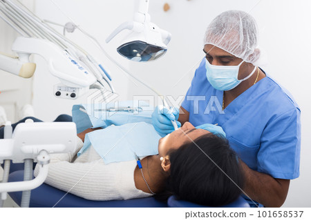 Stomatologist treating teeth of female patient in dental office 101658537