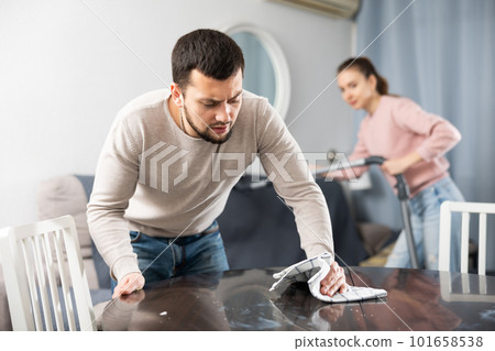 Wife and husband cleaning in apartment 101658538