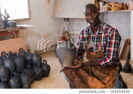 Potter checking quality of ceramic objects 101658540