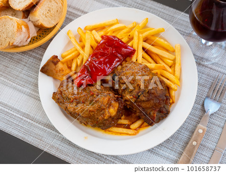 Spicy braised pork shank with fries and baked peppers Spicy braised pork shank with fries and baked peppers 101658737