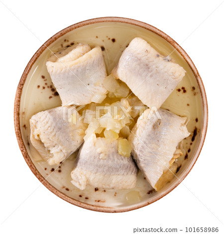 Plate with appetizer - rolls of salted Atlantic herring fillet with onions 101658986