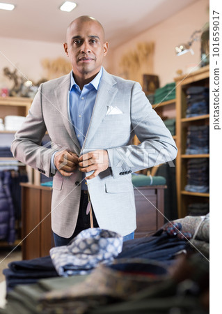 Man choosing suit jacket in clothing store 101659017