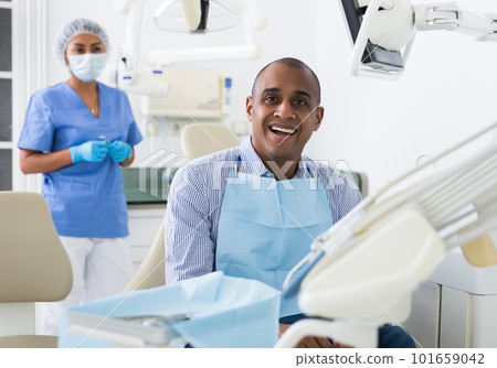 Man sitting in dental chair after teeth cure 101659042