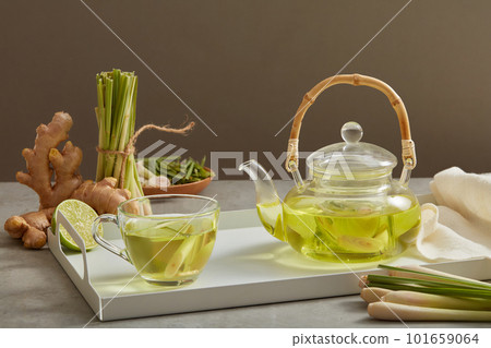 A glass transparent teapot and cup full filled with tea made with lemongrass, ginger and lemon. Improve immunity, losing weight, lowers cholesterol A glass transparent teapot and cup full filled with tea made with lemongrass, ginger and lemon. Improve immunity, losing weight, lowers cholesterol 101659064