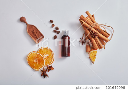 Flat lay cosmetic mockup with brown bottle without label, cinnamon sticks, anise, dried orange slices and coffee on white background. Health herbs, headache relief and reduce stress 101659096