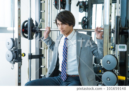 A young man doing weight training in a suit A young man doing weight training in a suit 101659148