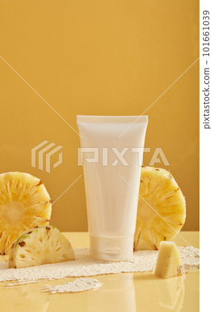 Front view of cosmetic with pineapple (Ananas comosus) extract in a white bottle with empty label on minimalist background. Natural cosmetics. Unbranded mock-up 101661039