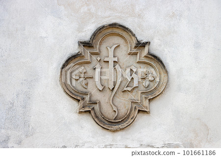 A monogram of the name of Jesus Christ on a facade of the church. A monogram of the name of Jesus Christ on a facade of the church. 101661186