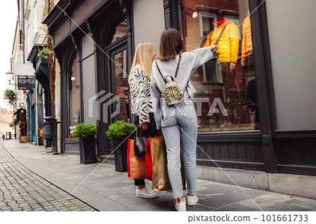 Back view of two women window shopping on the city streets Back view of two women window shopping on the city streets 101661733