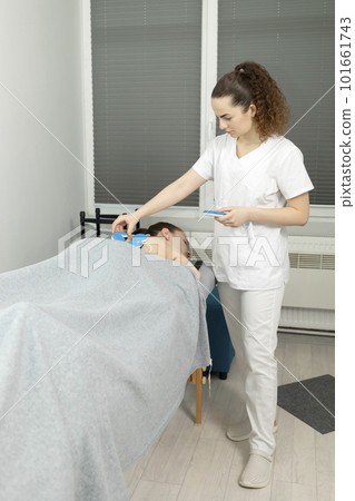 White Doctor, Physician Sets Wireless Electric Muscle Stimulator On Back Of Disabled Child With Cerebral Palsy. Massage, Rehabilitation. Children with disability, special needs. Vertical plane 101661743