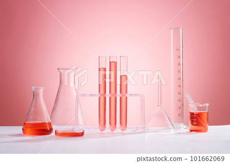 Front view of assortment of glass containers for laboratory, containing pink liquid and transparent empty podiums on pink background. Space for product presentation Front view of assortment of glass containers for laboratory, containing pink liquid and transparent empty podiums on pink background. Space for product presentation 101662069