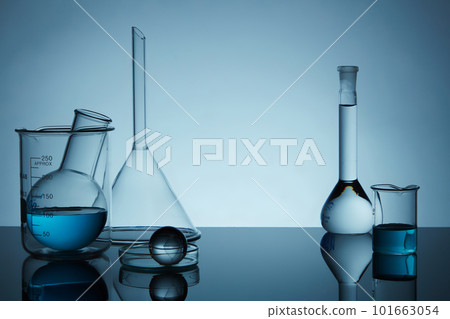 Blank minimal concept with laboratory equipment filled blue liquid on back lit background. Lab theme. Science and medical background 101663054