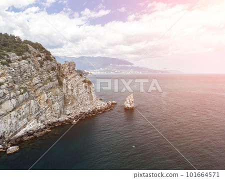 aerial photo of rock Parus Sail and Ayu-Dag Bear Mountain and near Gaspra, Yalta, Crimea at bright sunny day over the Black sea. Rock Parus in Gaspra near Swallow's nest in Crimea. 101664571