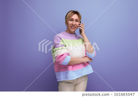 portrait of pleasant blond young woman in casual outfit smiling on purple background with copy space 101665047