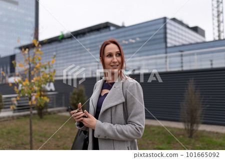 european young woman designer on the background of a strong glass building european young woman designer on the background of a strong glass building 101665092