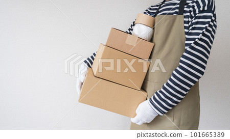 一個圍著圍裙的男人拿著紙板 | 搬家、整理和處理東西 Image 101665389