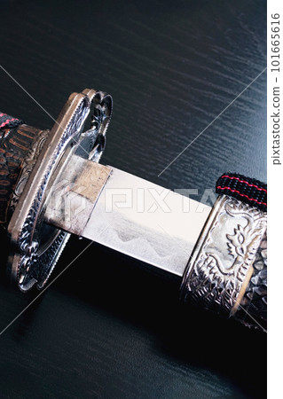 Samurai sword on a black wooden table Samurai sword on a black wooden table 101665616