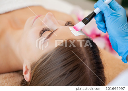 Portrait of a young woman getting spa treatment and face massage at beauty salon. Portrait of a young woman getting spa treatment and face massage at beauty salon. 101666997